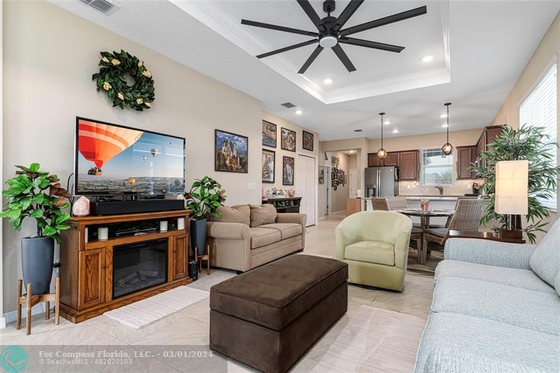 9857 Southwest 99th Loop Ocala, FL 34481 - Photo 17 of 45 a living room with furniture a flat screen tv and a fireplace