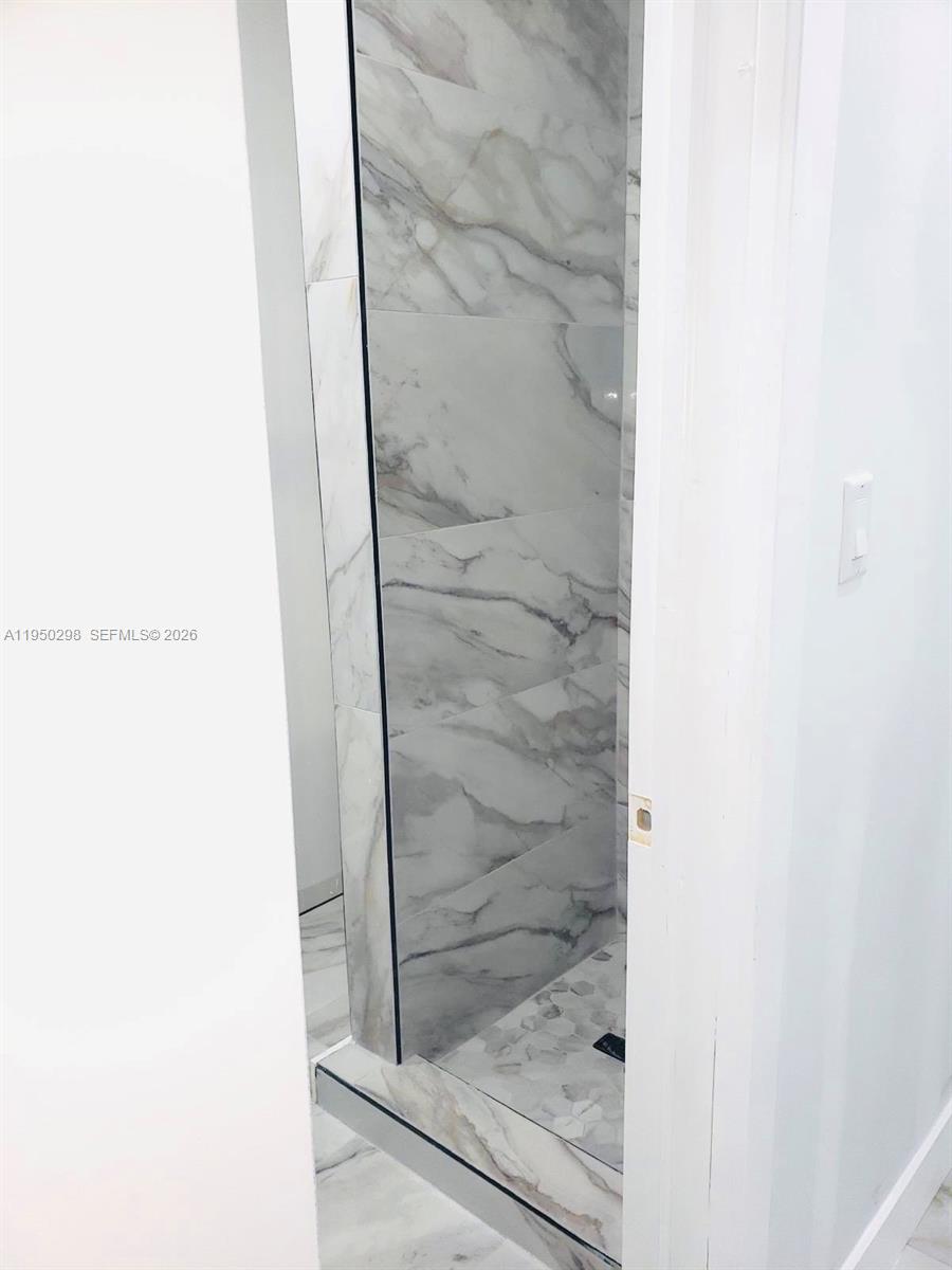 270 Northeast 162nd Street, Unit B Miami, FL 33162 - Photo 4 of 7 a bathroom with a glass shower door