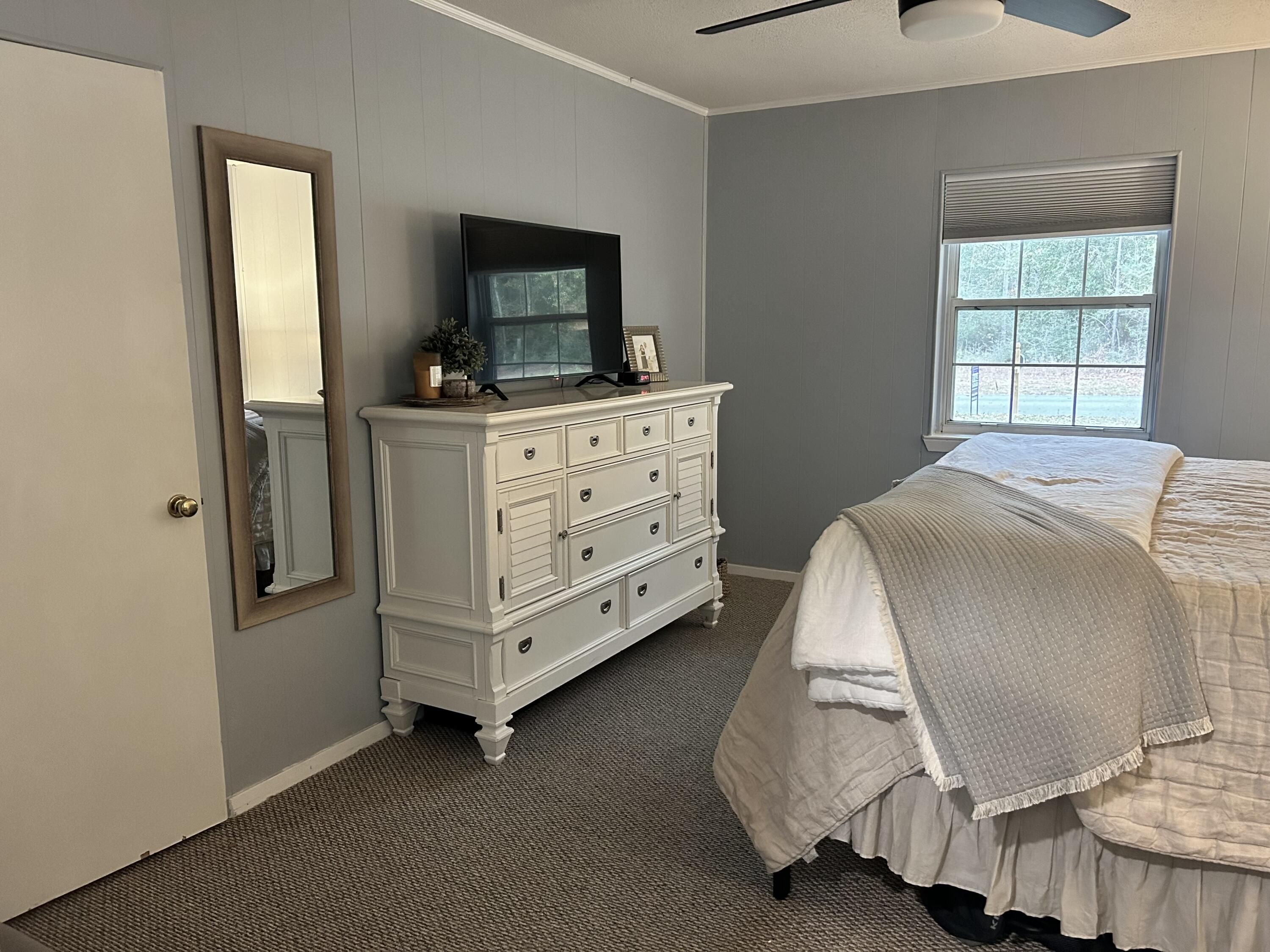 1764 Adams Road DeFuniak Springs, FL 32433 - Photo 4 of 30 a bedroom with a bed and flat tv screen on the dresser