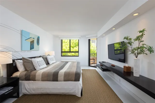 a spacious bedroom with a bed and a flat screen tv