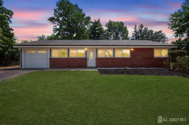 a front view of a house with a garden and yard