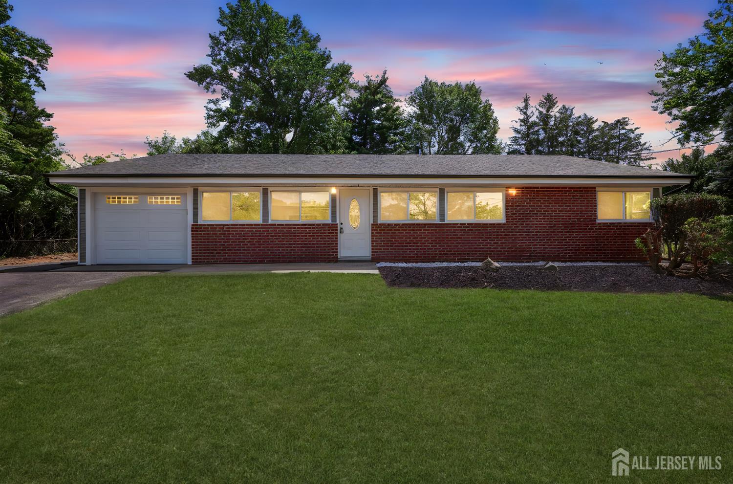 a front view of a house with a garden and yard