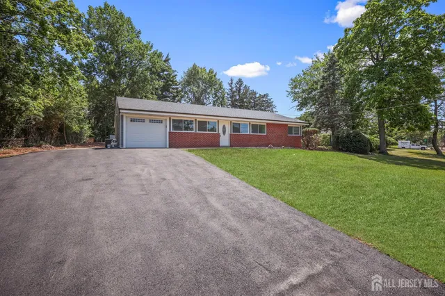 a view of a house with a yard and large tree