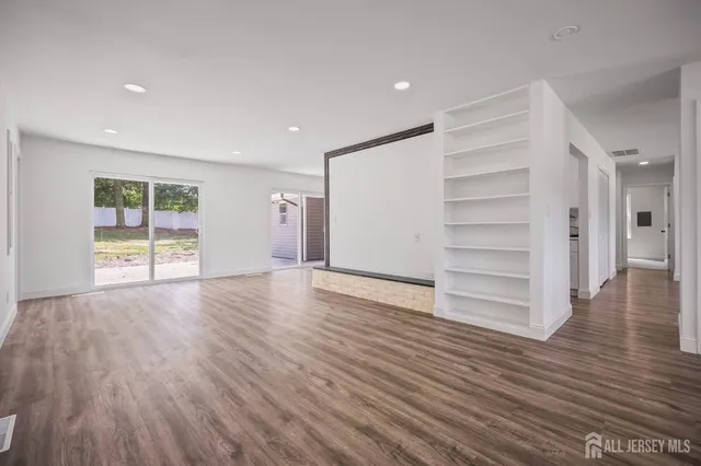 a view of empty room with wooden floor and window