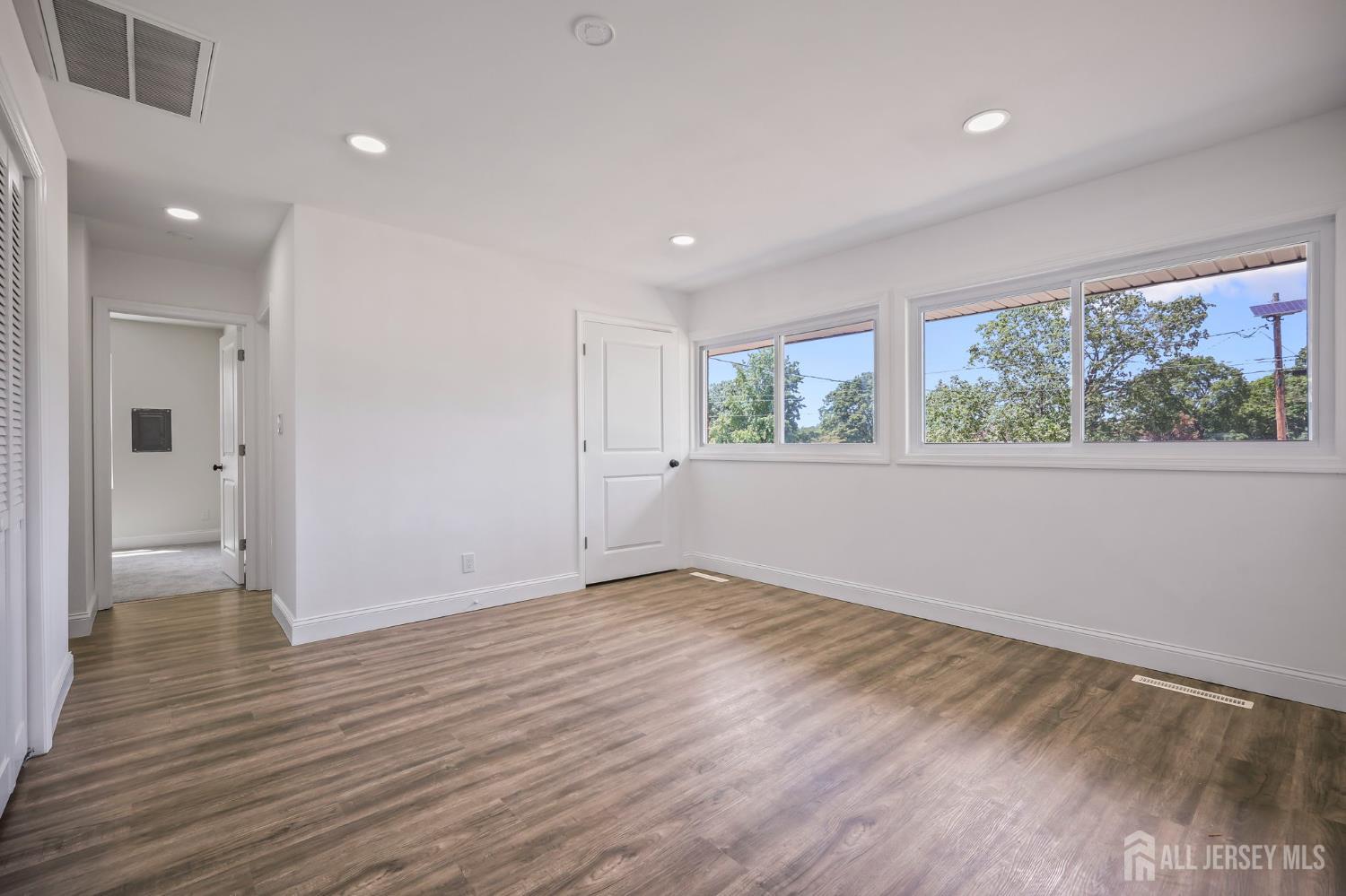 12 Dillon Road Kendall Park, NJ 08824 - Photo 17 of 48 a view of an empty room with wooden floor and a window