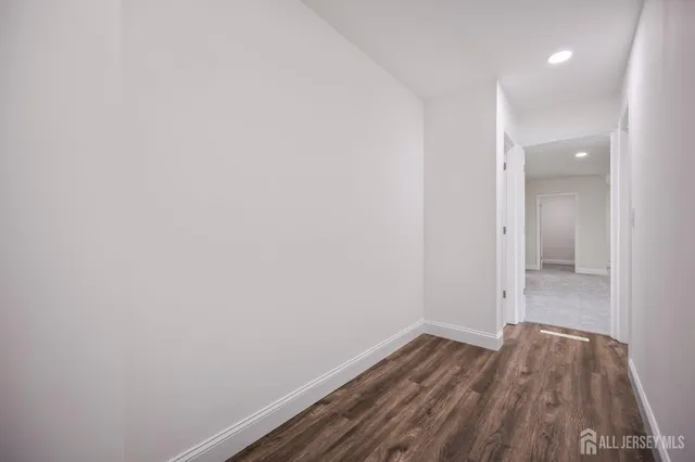 a view of a room with wooden floor and white walls
