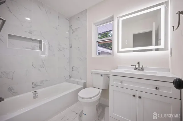 a bathroom with a granite countertop toilet a sink and a bathtub