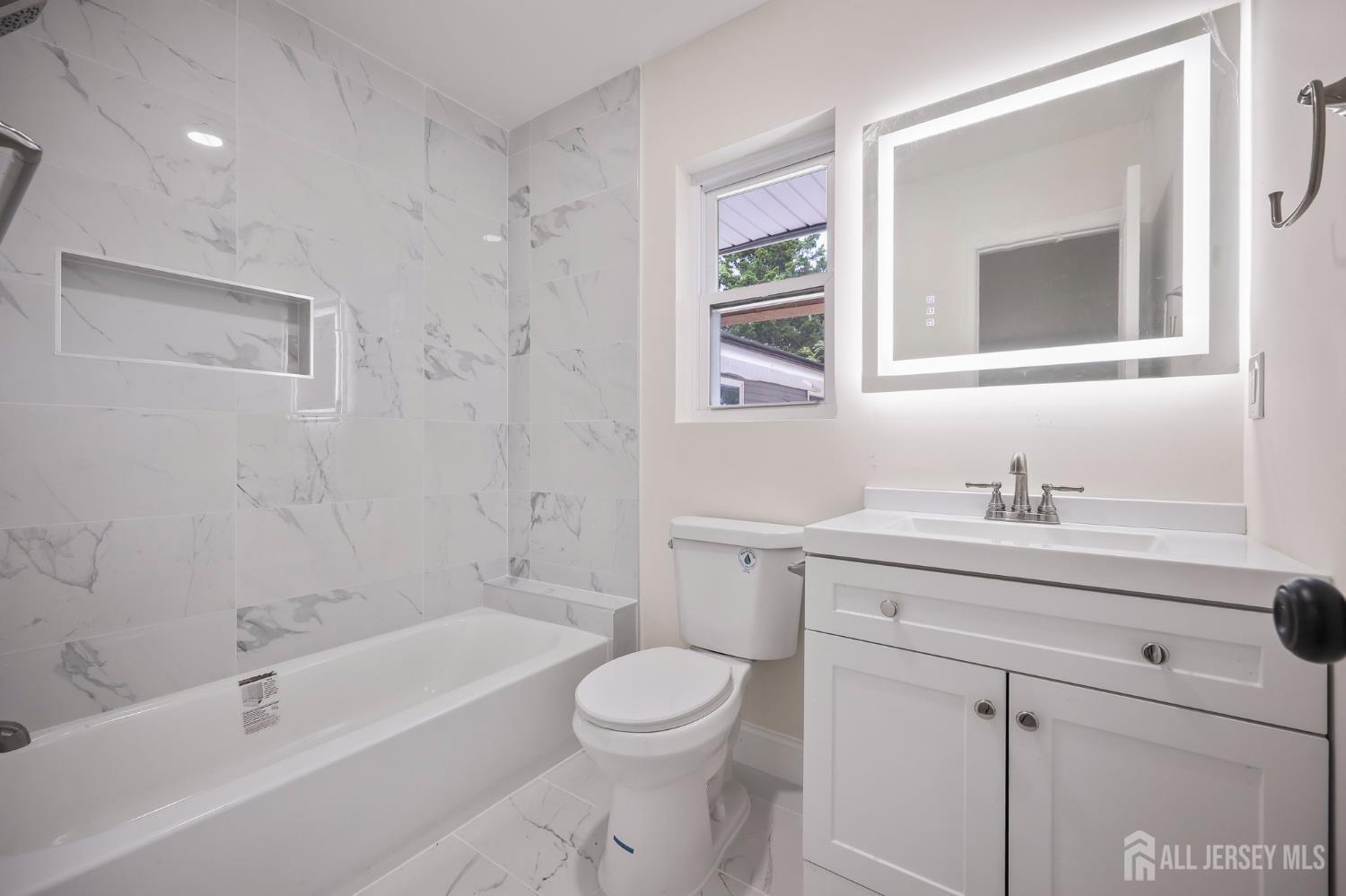 12 Dillon Road Kendall Park, NJ 08824 - Photo 31 of 48 a bathroom with a granite countertop toilet a sink and a bathtub