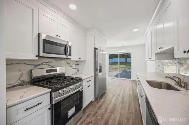 a kitchen that has a sink and a stove top oven