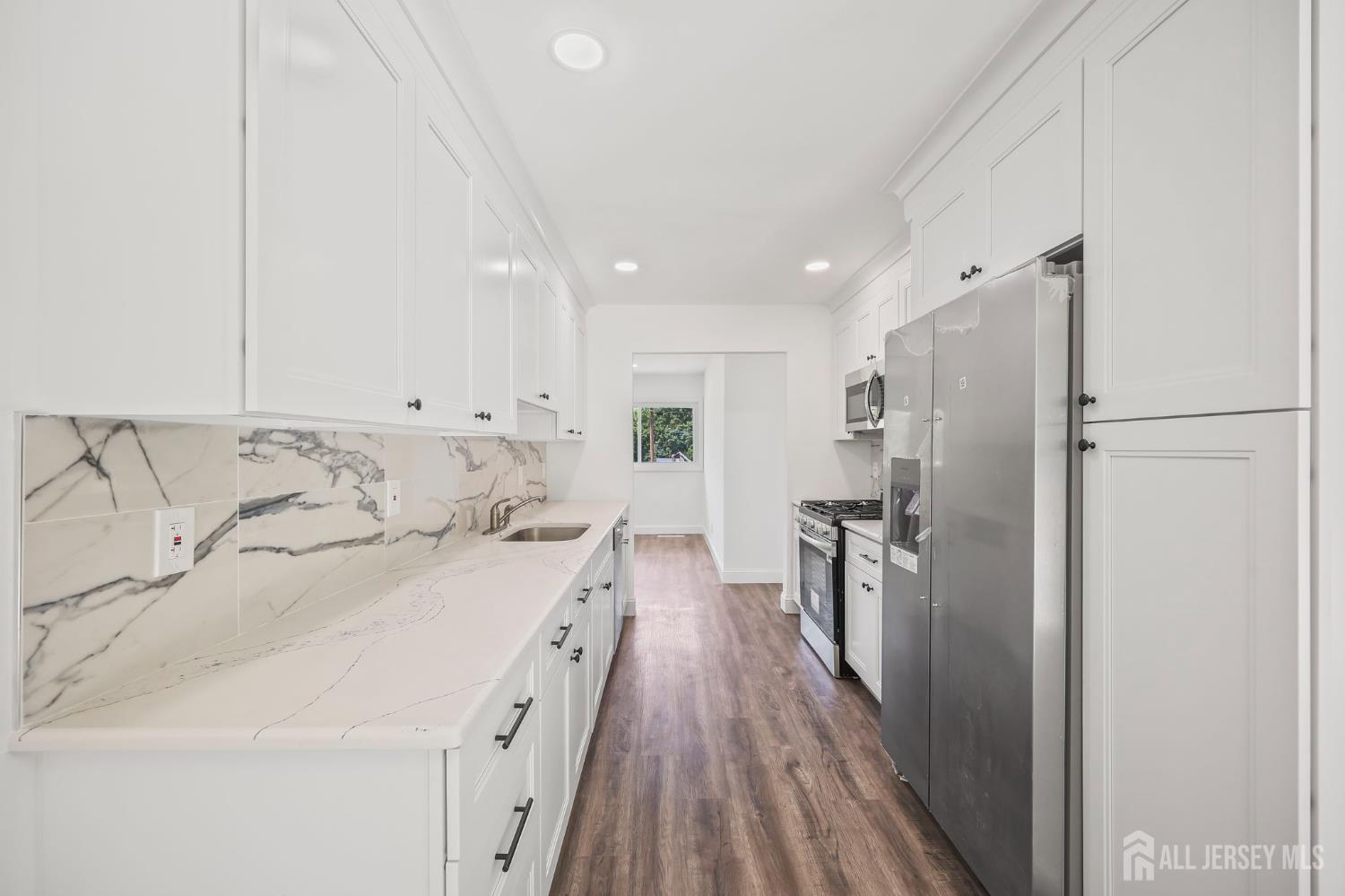 12 Dillon Road Kendall Park, NJ 08824 - Photo 37 of 48 a large white kitchen with a stove a refrigerator a sink dishwasher and a oven with wooden floor