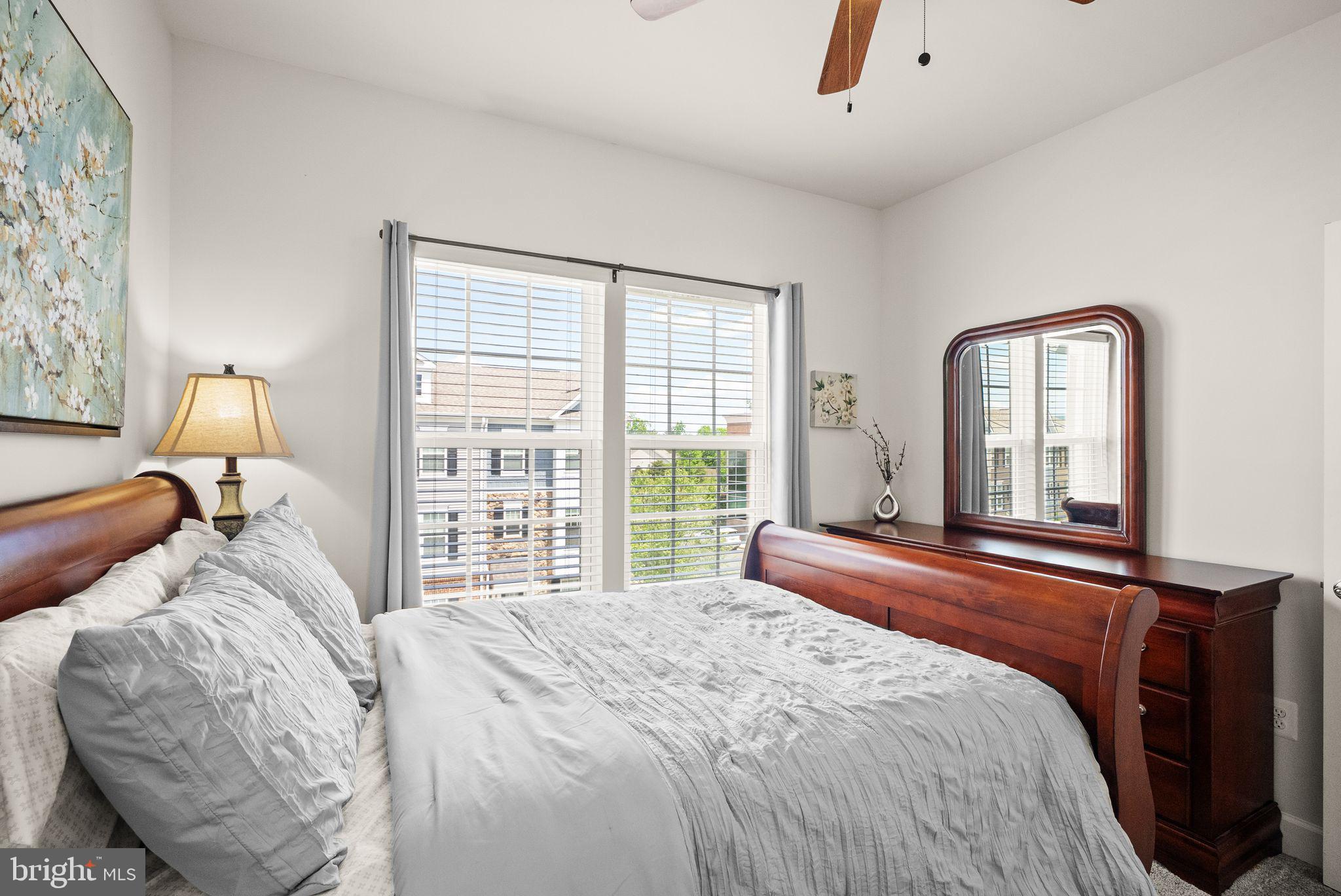 13803 Litespeed Way Gainesville, VA 20155 - Photo 24 of 37 a bedroom with a bed a mirror and a large window