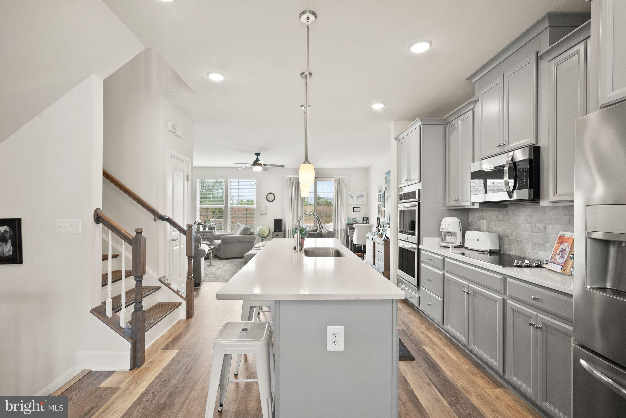 13803 Litespeed Way Gainesville, VA 20155 - Photo 8 of 37 a kitchen with counter top space a sink stainless steel appliances and cabinets
