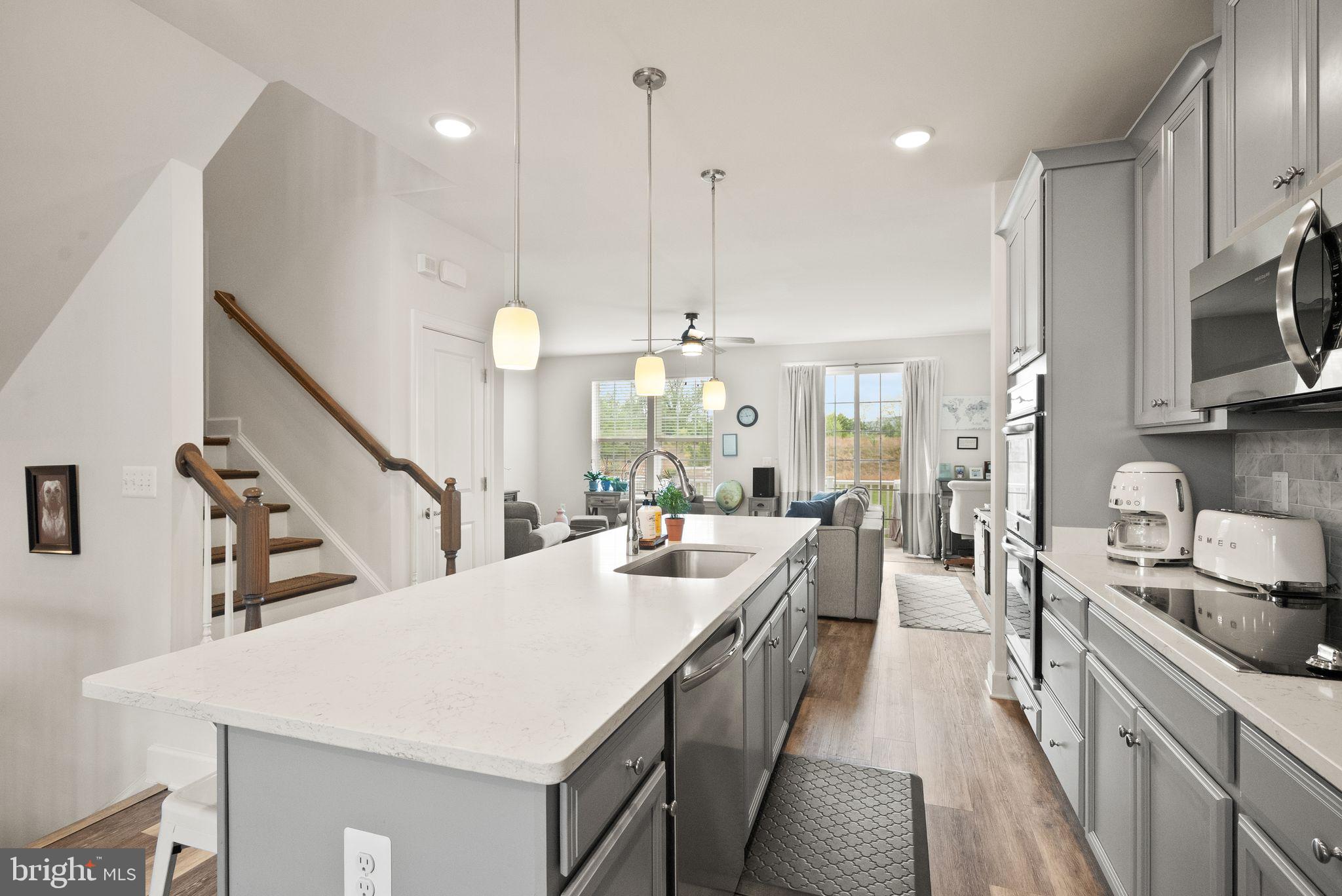 13803 Litespeed Way Gainesville, VA 20155 - Photo 9 of 37 a large kitchen with kitchen island a sink a counter space appliances and cabinets