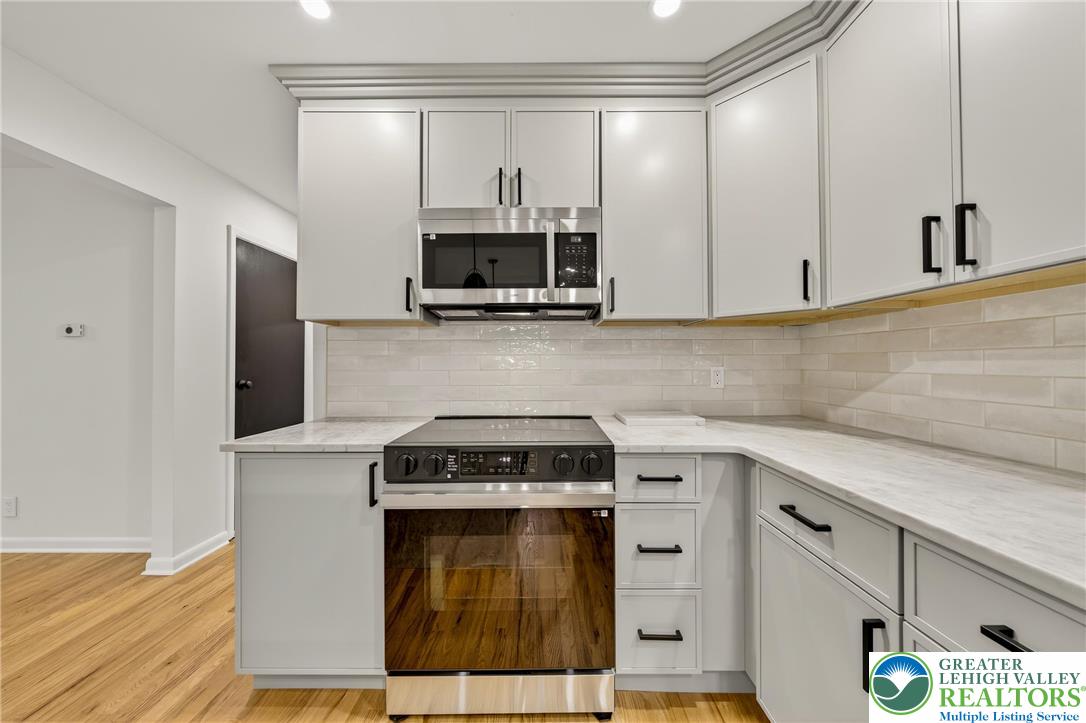 1285 Stafore Drive Bethlehem, PA 18017 - Photo 12 of 56 a kitchen with stainless steel appliances a stove a microwave and cabinets