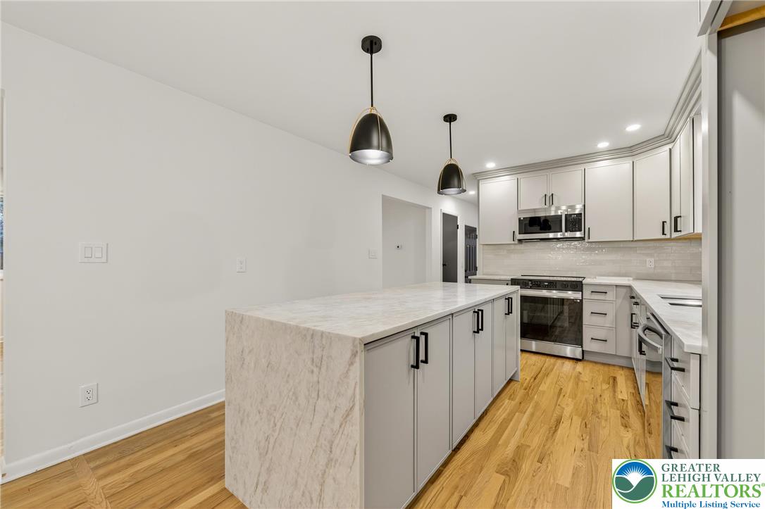 1285 Stafore Drive Bethlehem, PA 18017 - Photo 17 of 56 a kitchen with stainless steel appliances granite countertop a sink a stove and a wooden floors