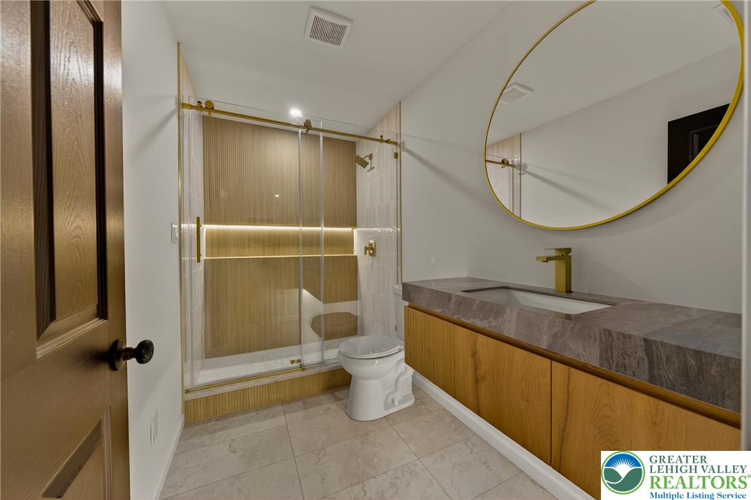 1285 Stafore Drive Bethlehem, PA 18017 - Photo 30 of 56 a bathroom with a granite countertop sink a toilet and shower