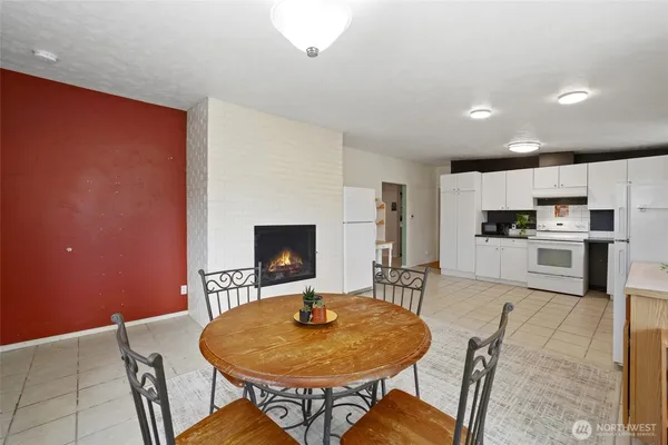 a living room with furniture a fireplace and kitchen view