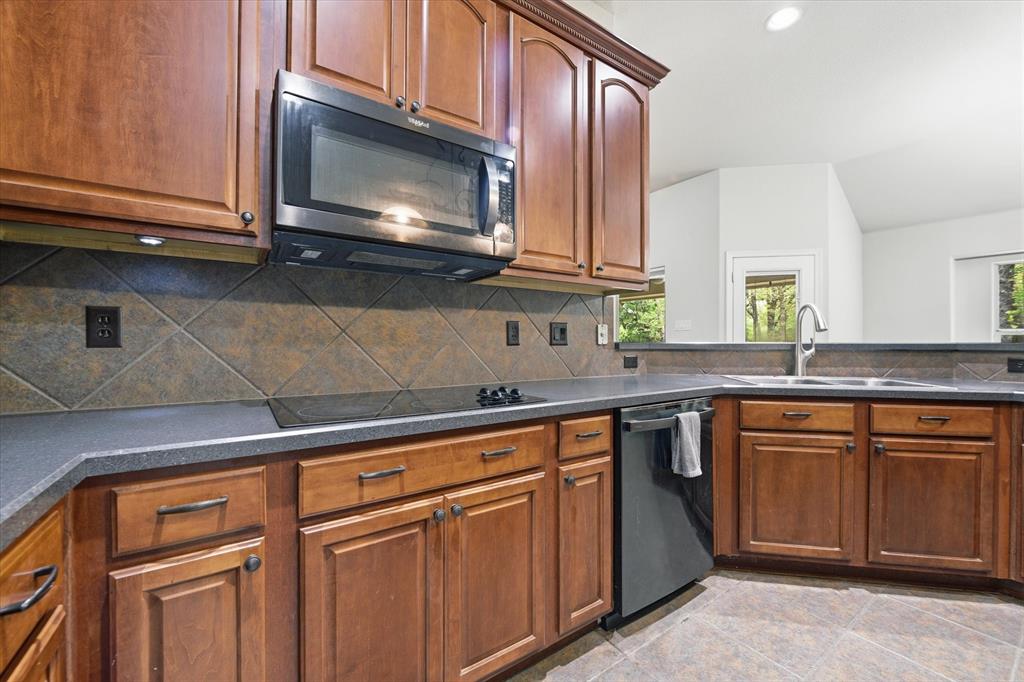 5992 Red Bud Road Fort Worth, TX 76135 - Photo 16 of 40 a kitchen with granite countertop cabinets stainless steel appliances and a sink
