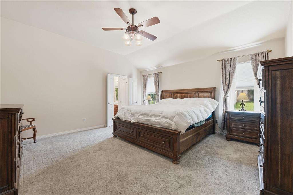 5992 Red Bud Road Fort Worth, TX 76135 - Photo 20 of 40 a bedroom with a bed chandelier and a window