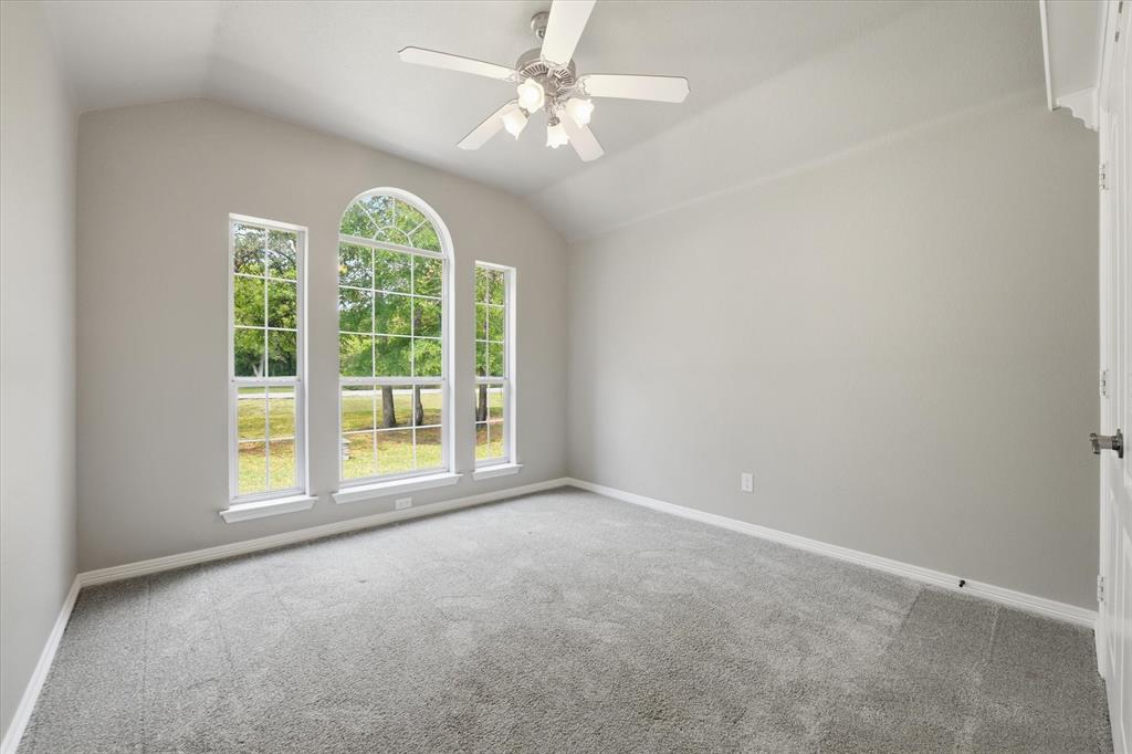 5992 Red Bud Road Fort Worth, TX 76135 - Photo 26 of 40 an empty room with windows and ceiling fan