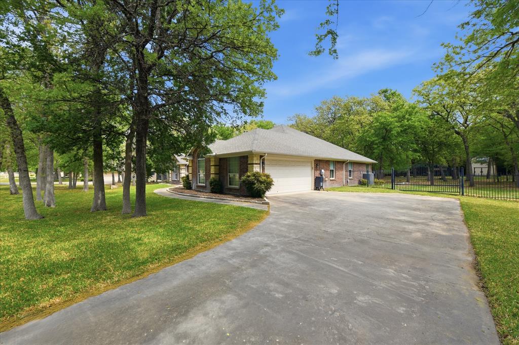 5992 Red Bud Road Fort Worth, TX 76135 - Photo 6 of 40 a front view of a house with a yard and trees