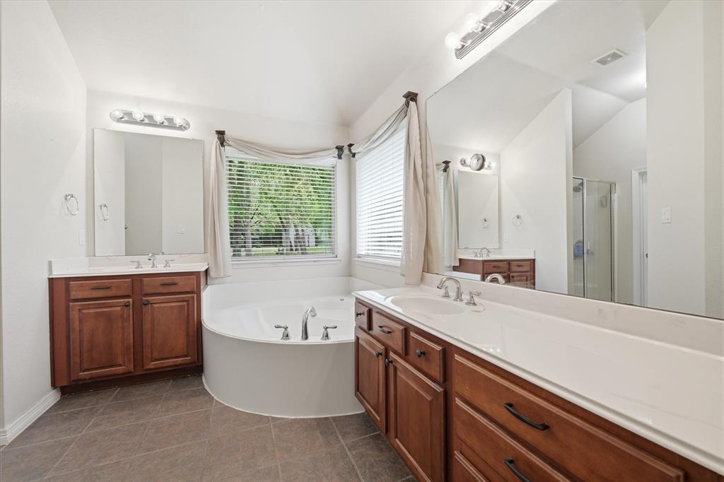5992 Red Bud Road Fort Worth, TX 76135 - Photo 9 of 40 a spacious bathroom with a tub sink and mirror