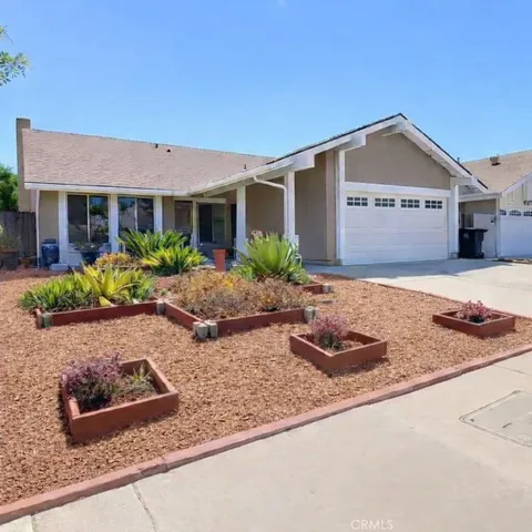 a front view of house with yard and trees in the background