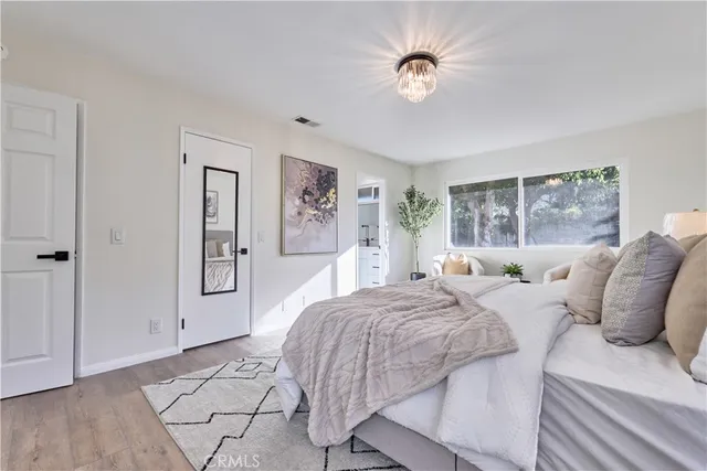 a bedroom with a large bed and a chandelier