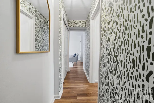 a view of a hallway with wooden floor and a large window