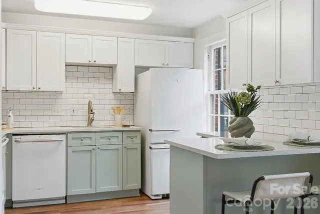 a kitchen with appliances cabinets and chair