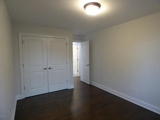 an empty room with wooden floor and closet