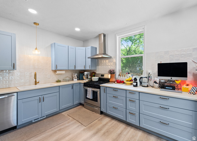 257 200 South Provo, UT 84606 - Photo 8 of 40 Kitchen with stainless steel appliances, light wood-style floors, decorative light fixtures, and backsplash