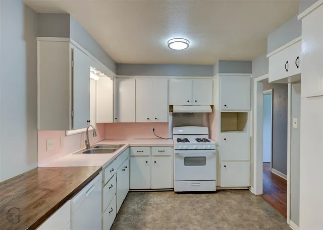 a kitchen with a stove sink and cabinets