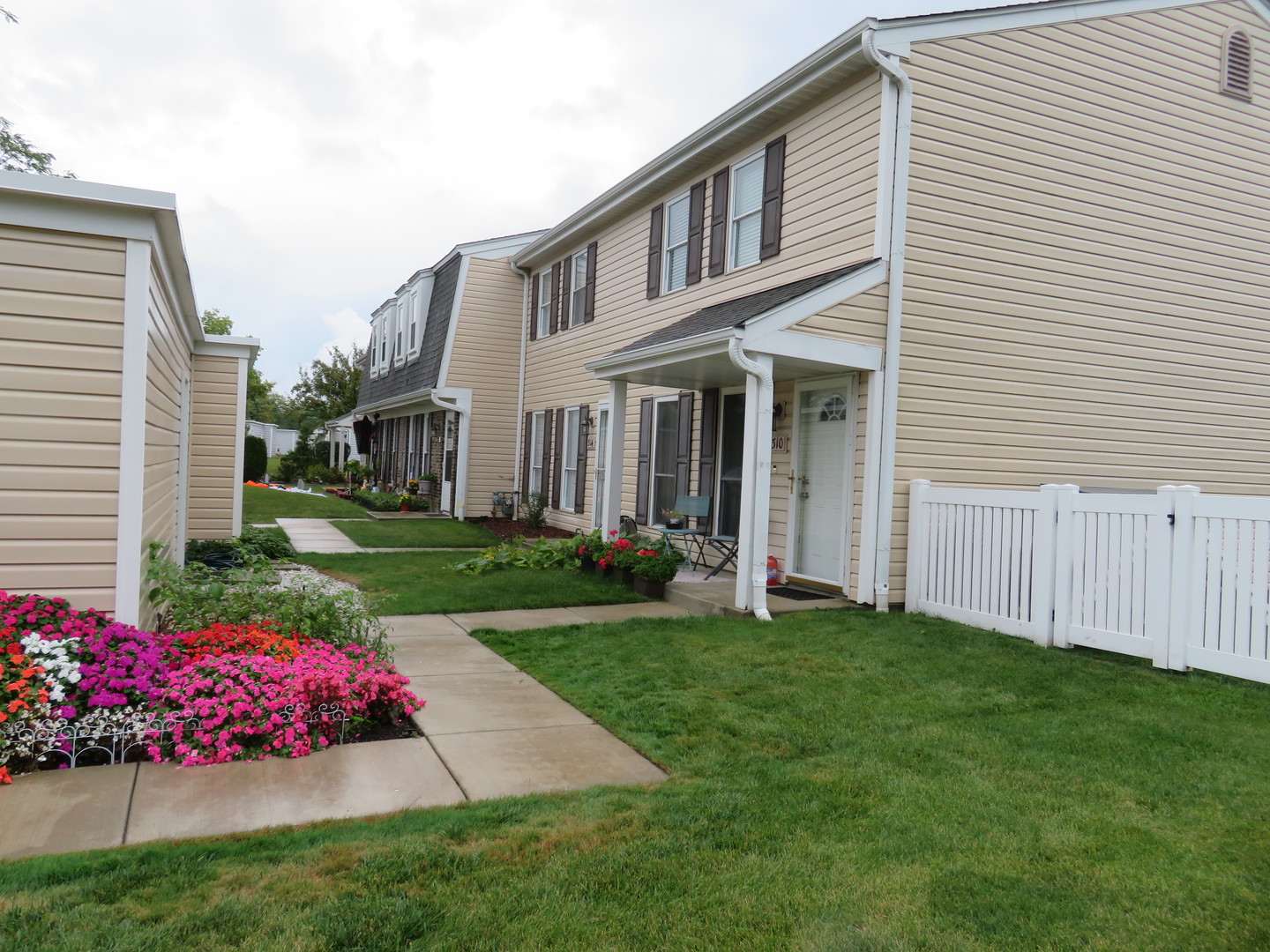 a front view of a house with a garden and yard