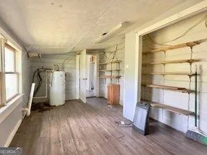 a view of empty room with wooden floor and window