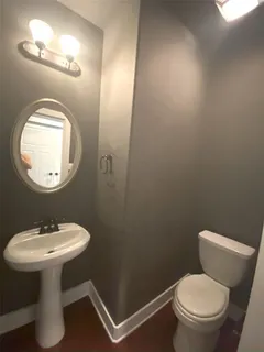 a bathroom with a sink toilet and a mirror