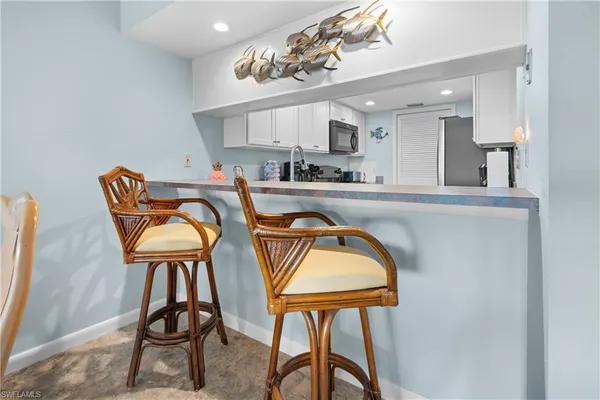 a dining room filled chandelier and kitchen view