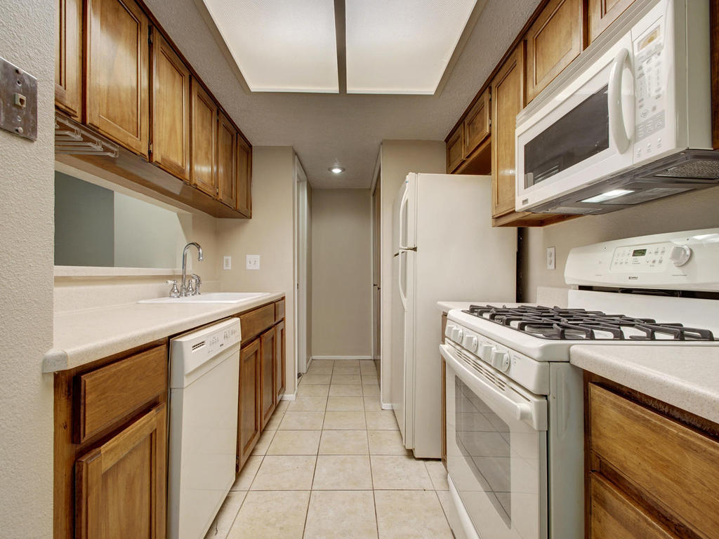 11301 Jollyville Road, Unit A3 Austin, TX 78759 - Photo 13 of 26 a kitchen with stainless steel appliances granite countertop a stove and a sink