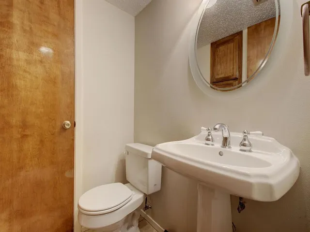 a bathroom with a toilet a sink and mirror