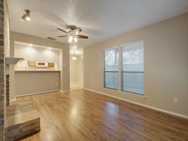 a view of a kitchen with wooden floor and a ceiling fan