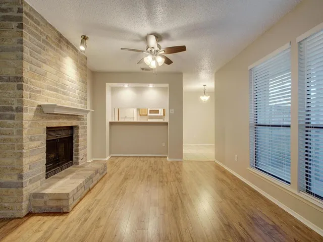 a view of an empty room with a kitchen and a window