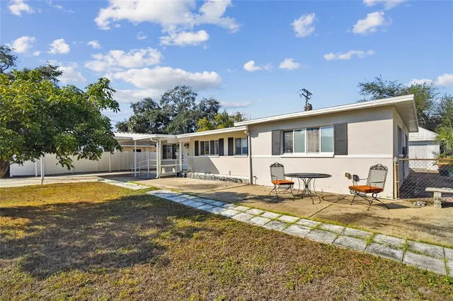 a view of a house with pool and sitting area