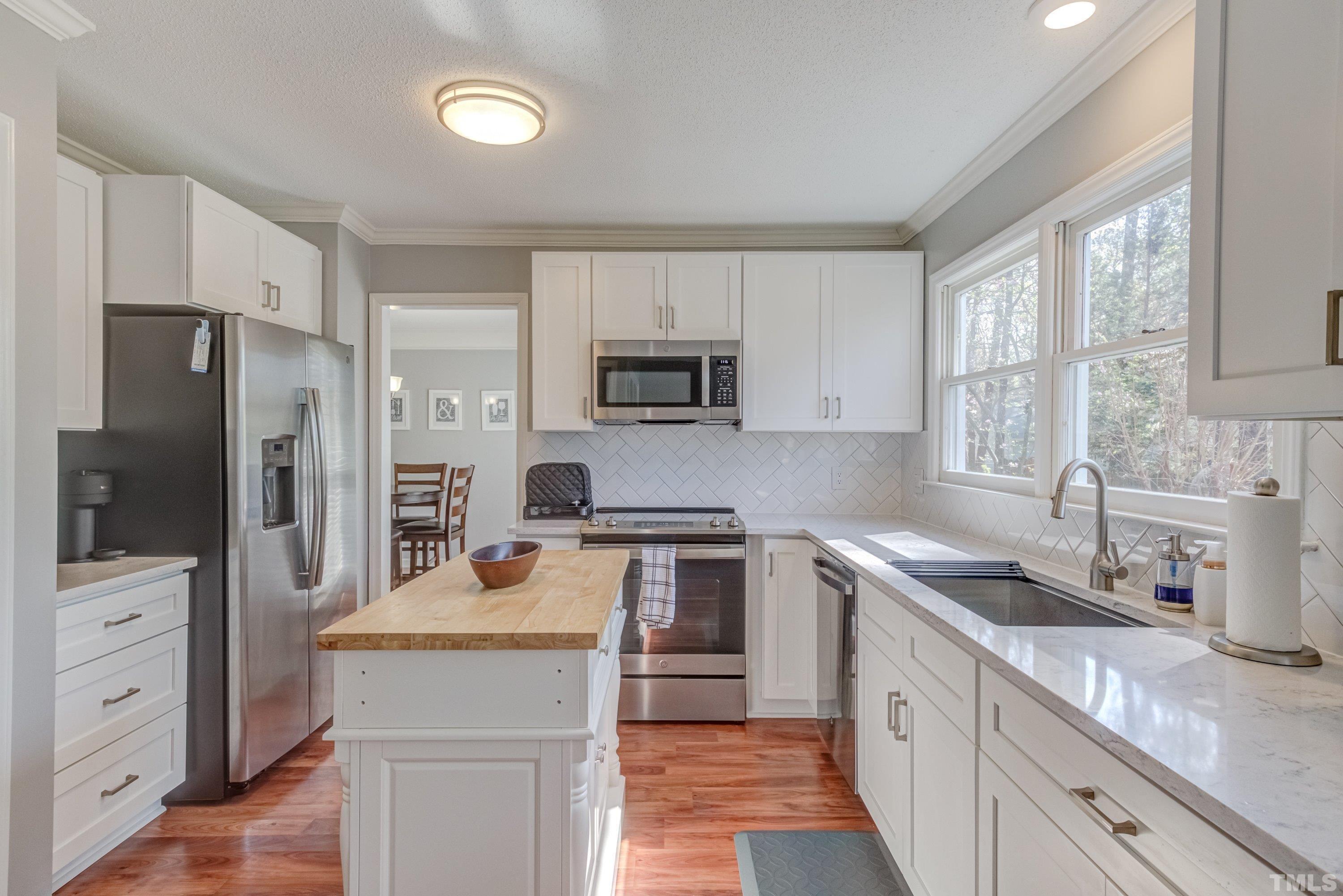 105 McIntire Lane Cary, NC 27513 - Photo 14 of 32 a kitchen with a sink stove refrigerator and cabinets