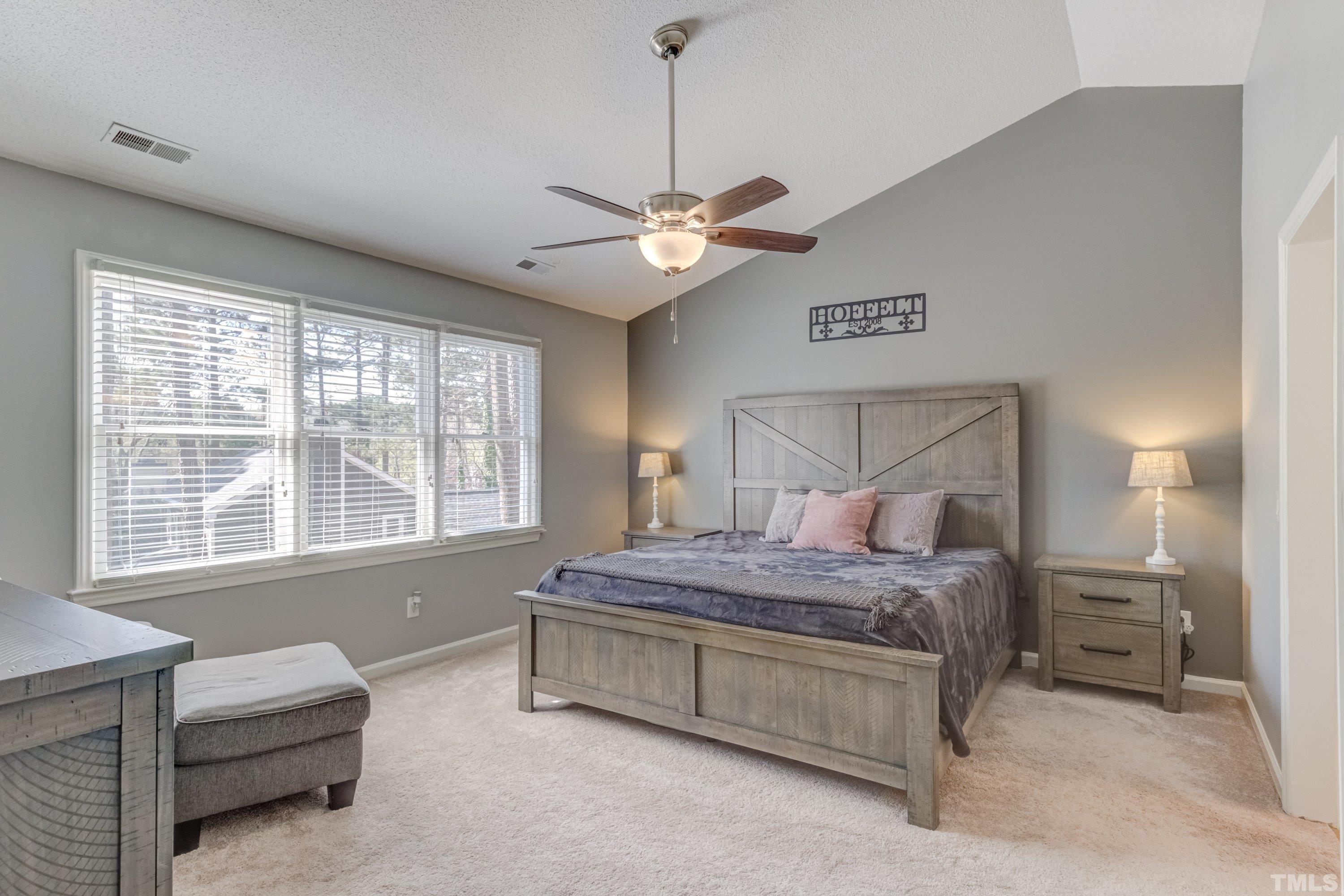 105 McIntire Lane Cary, NC 27513 - Photo 18 of 32 a bedroom with a bed chandelier and a window