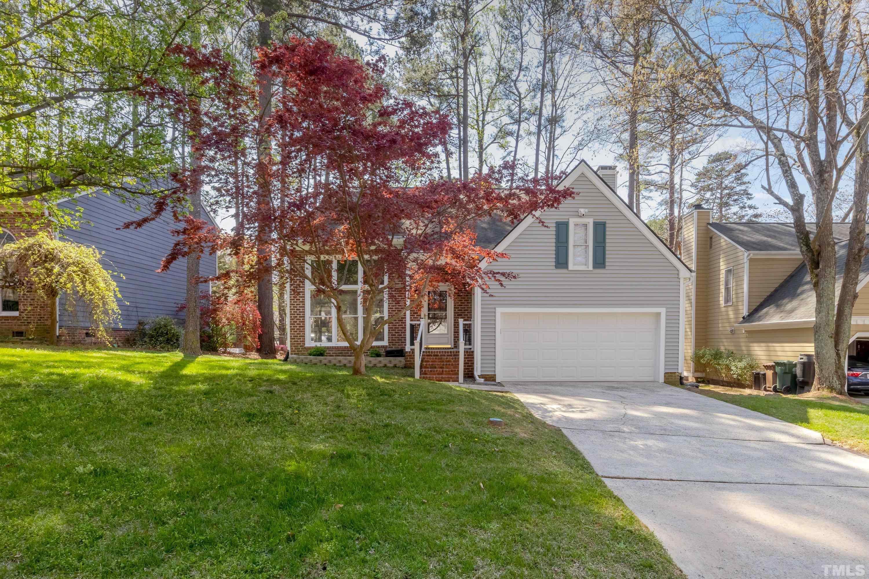 105 McIntire Lane Cary, NC 27513 - Photo 2 of 32 a front view of a house with a garden and trees