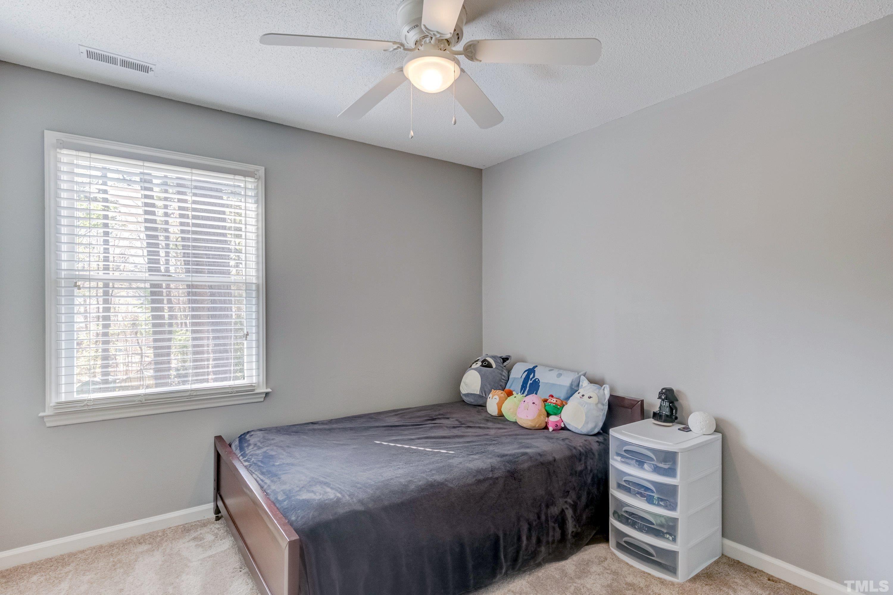 105 McIntire Lane Cary, NC 27513 - Photo 22 of 32 a bedroom with a bed and a chandelier