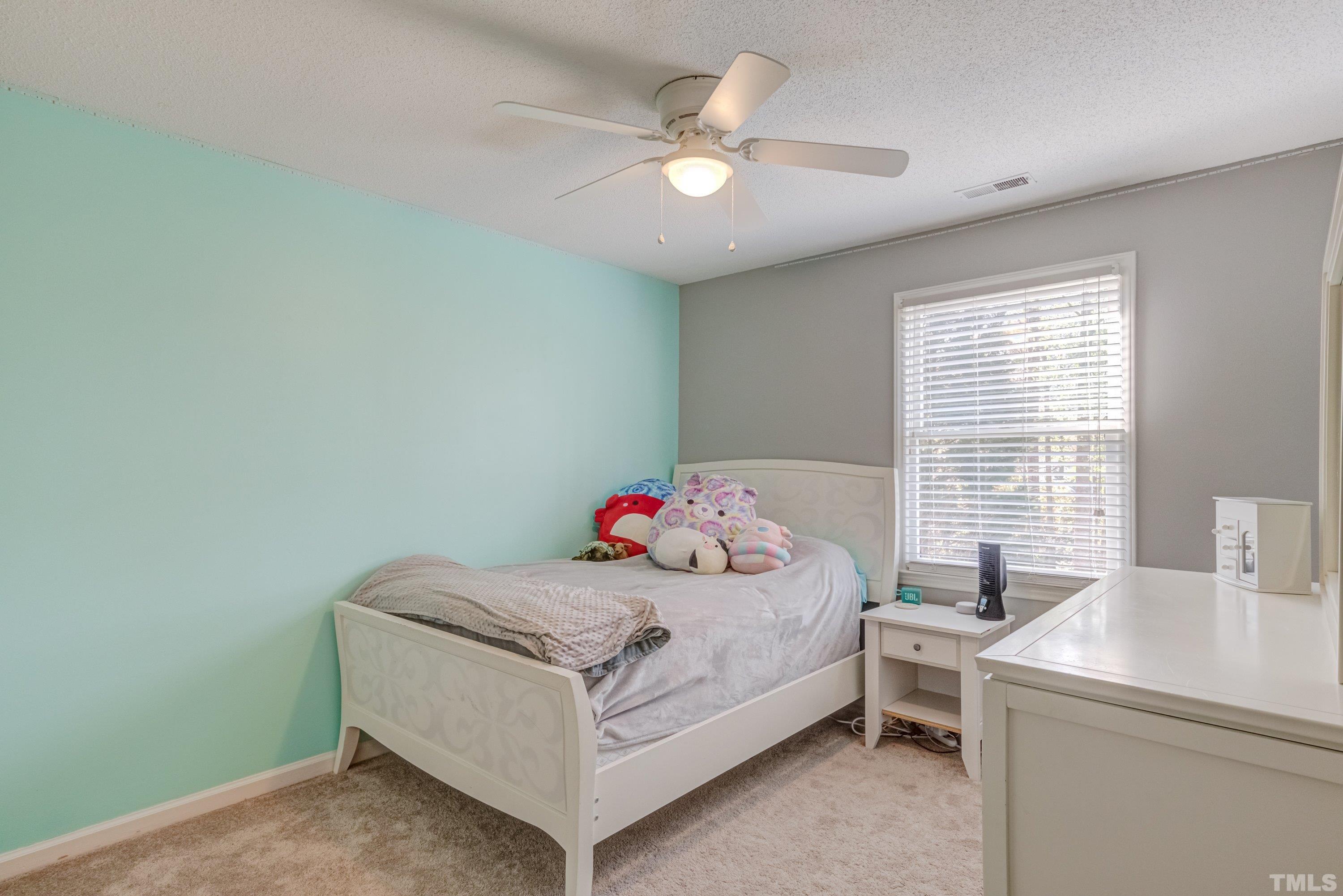 105 McIntire Lane Cary, NC 27513 - Photo 23 of 32 a bedroom with a bed and a chandelier