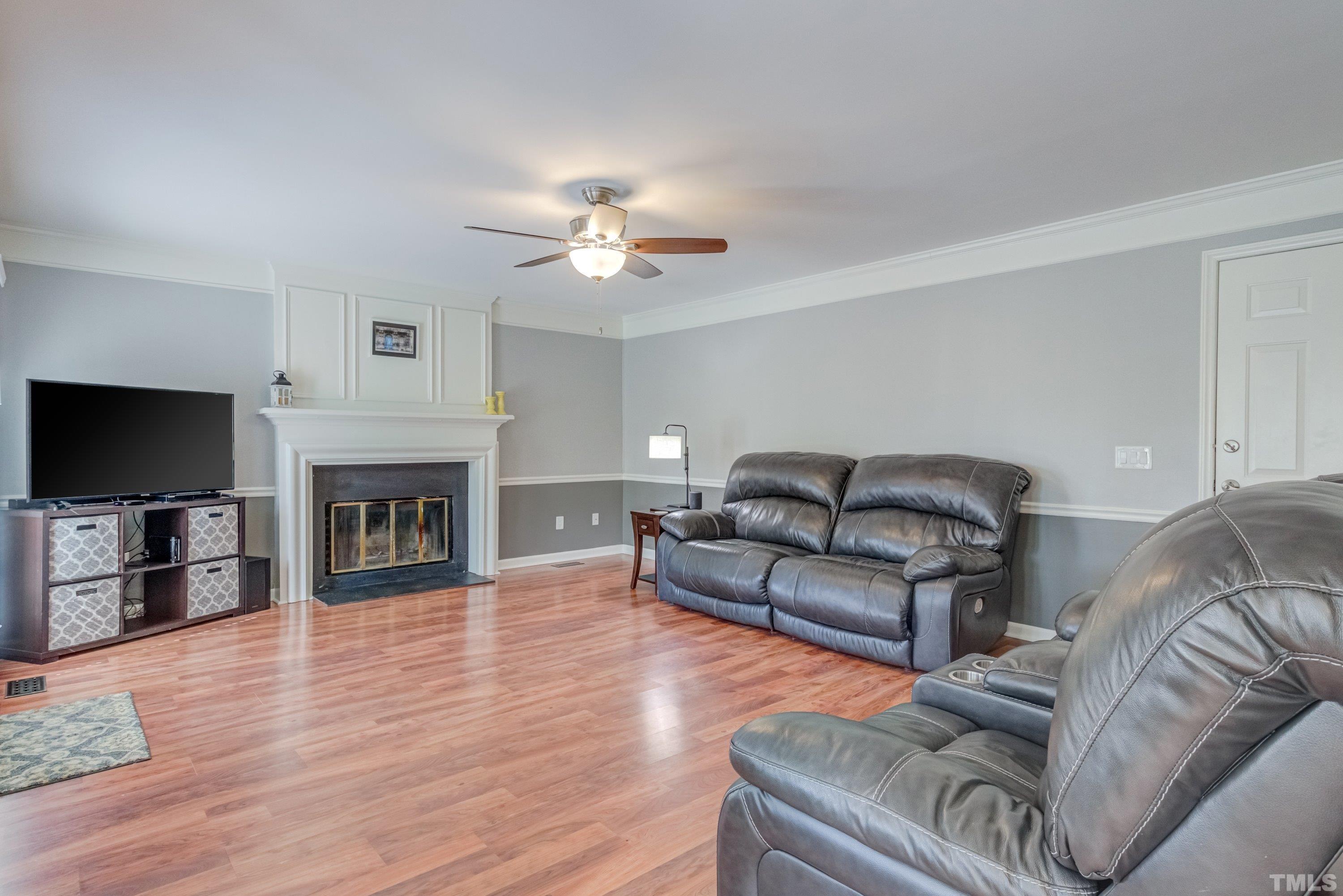 105 McIntire Lane Cary, NC 27513 - Photo 8 of 32 a living room with furniture a fireplace and a flat screen tv