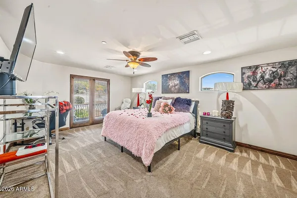 a room with chandelier fan and wooden floor