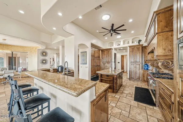 a large kitchen with stainless steel appliances kitchen island granite countertop a sink and cabinets